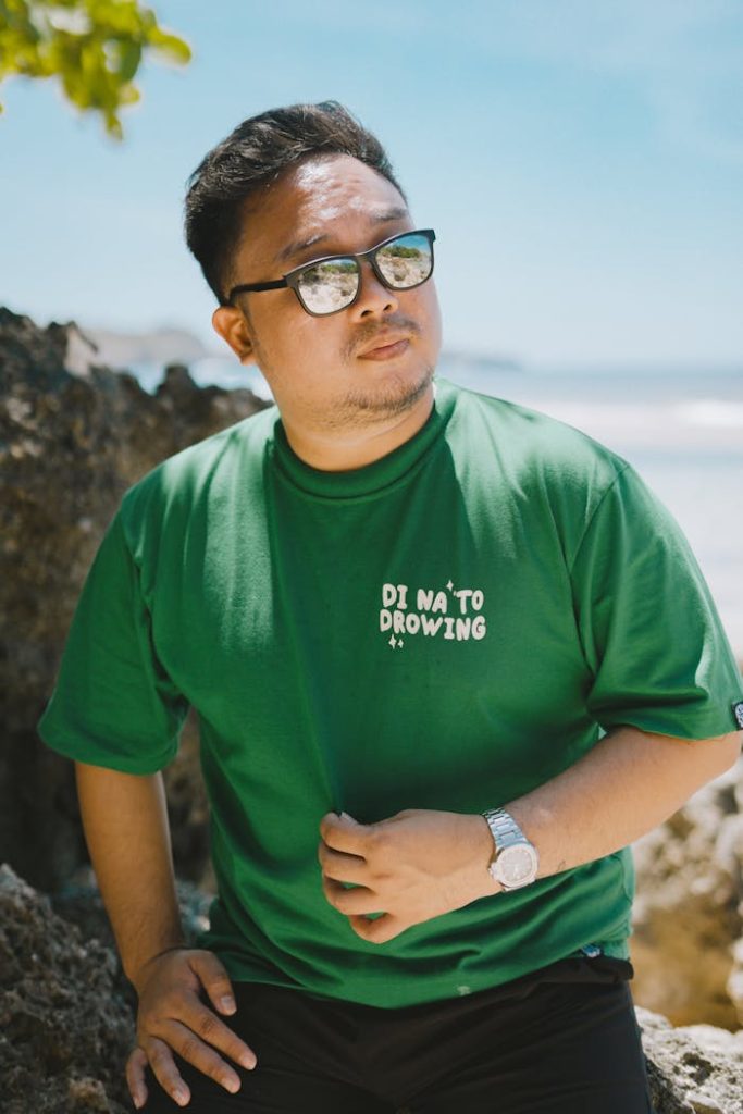 A man wearing a green shirt and sunglasses